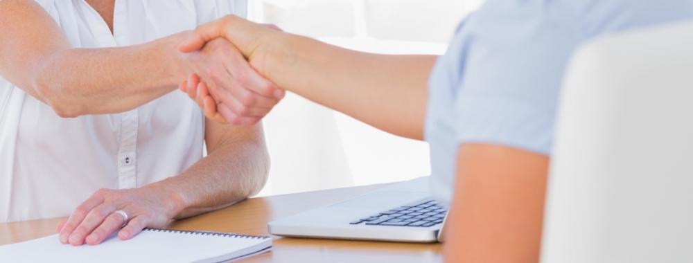 Cheerful interviewer shaking hand of an applicant.jpg